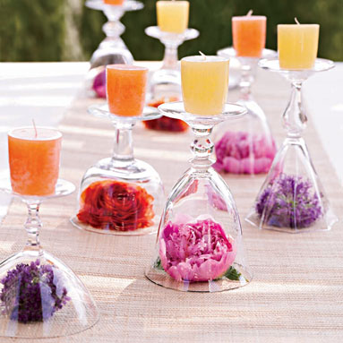 a centerpiece with a flower inside of the glass and a candle on the top